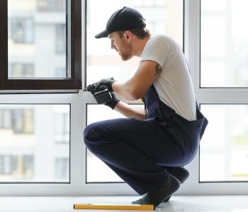 workman-overalls-installing-adjusting-plastic-windows-living-room-home_255667-64422